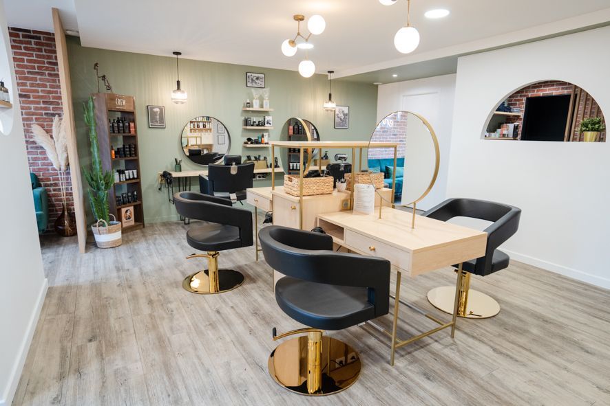 Intérieur moderne d'un salon de coiffure avec fauteuils de coiffure, miroirs et parquet clair