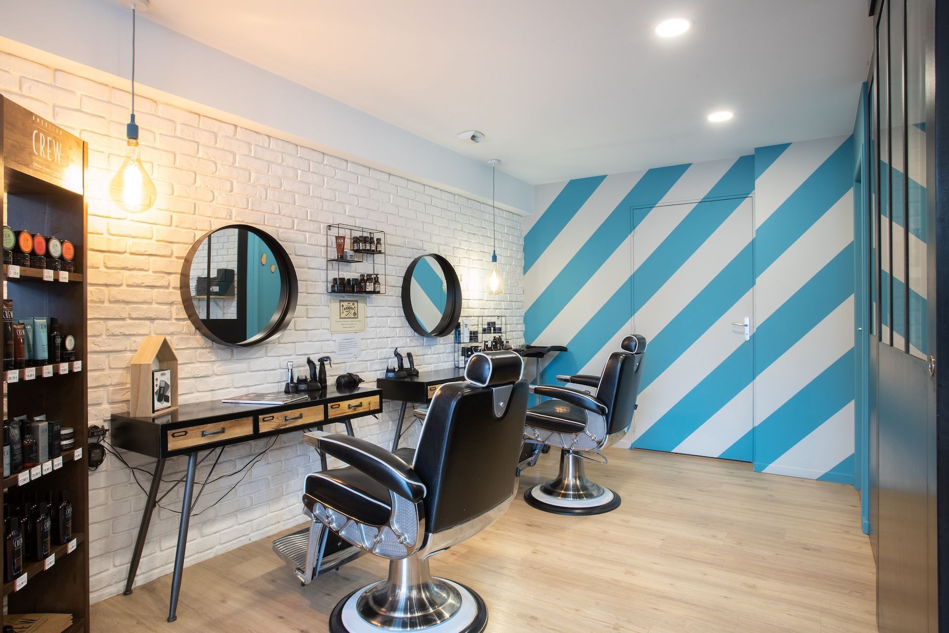Intérieur moderne d'un salon de coiffure avec fauteuils de coiffure, miroirs et mur d'accent à rayures bleues
