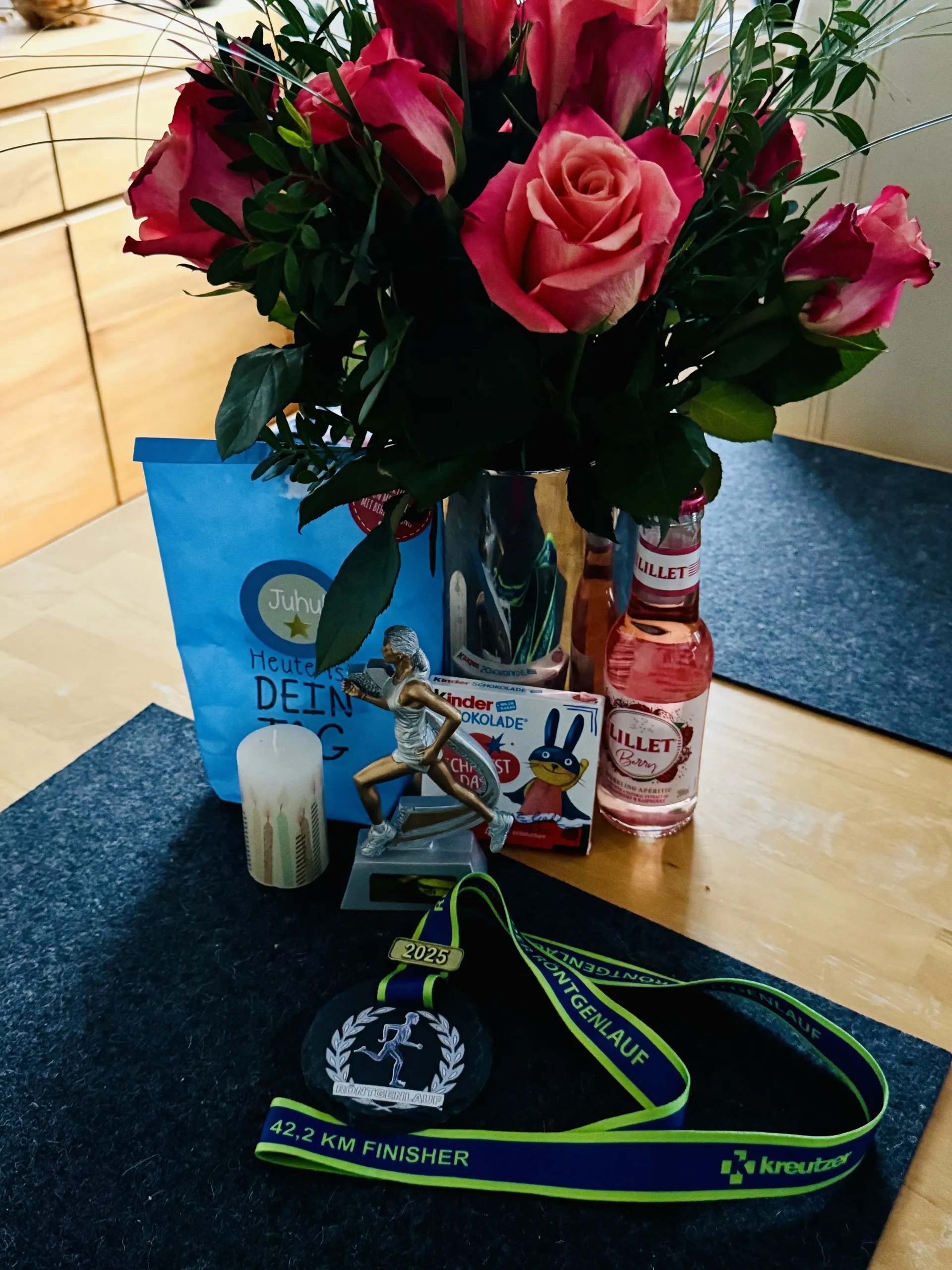 Rosen, Medaille, Pokal und Getränke auf einem Tisch. Feierliche Szene.