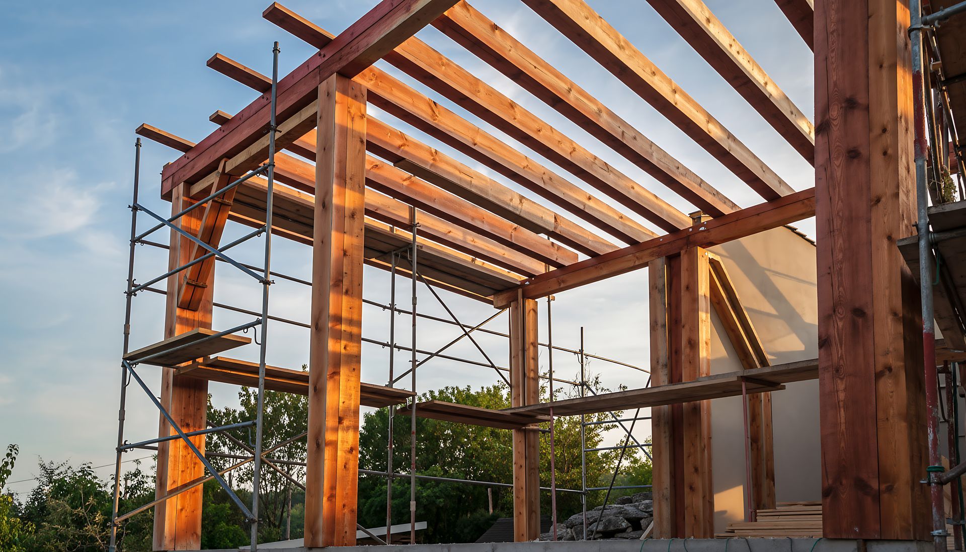 Ossature bois d'un bâtiment en construction, avec échafaudages et poutres horizontales.
