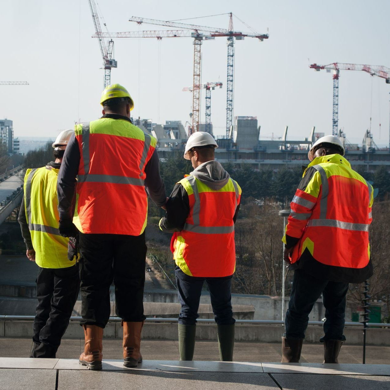 Ouvriers de dos devant un chantier