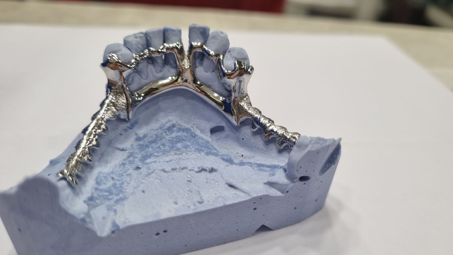 Un modelo de los dientes de una persona está sentado sobre una superficie blanca.