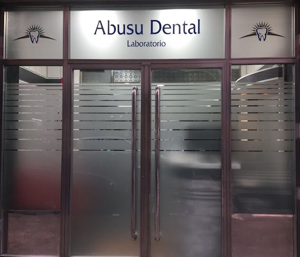 El laboratorio dental abusu está ubicado en un edificio con puerta de cristal.