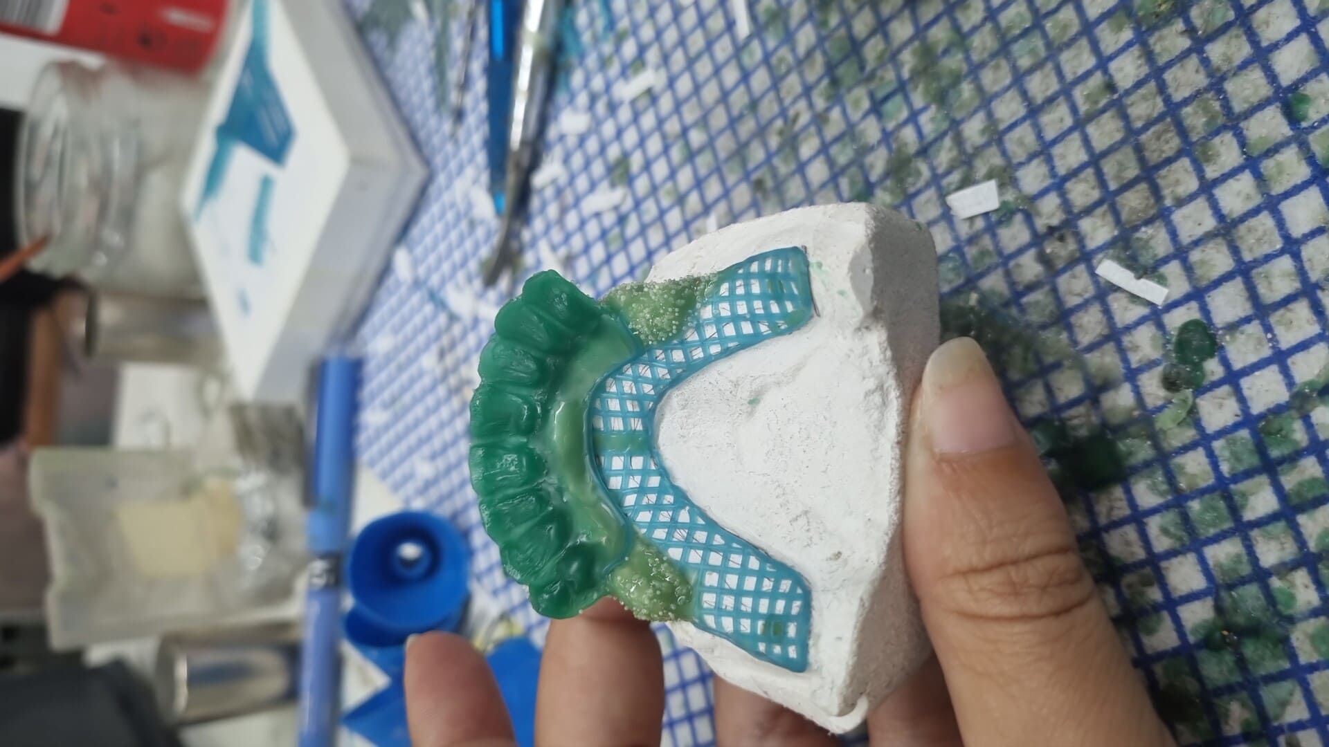 Una persona sostiene en su mano un trozo de pieza dental.