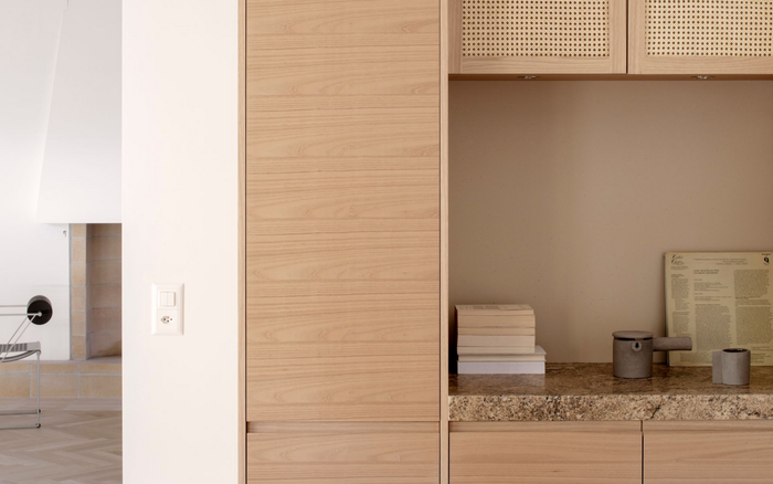 Meuble de rangement intégré en bois avec niches ouvertes pour objets blancs. Parois beiges, dessus blanc.