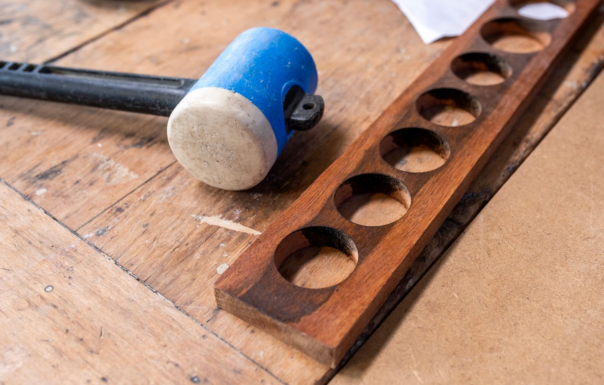 Coin salon avec mobilier bleu, mur géométrique, luminaire globe argenté et petites tables noires.