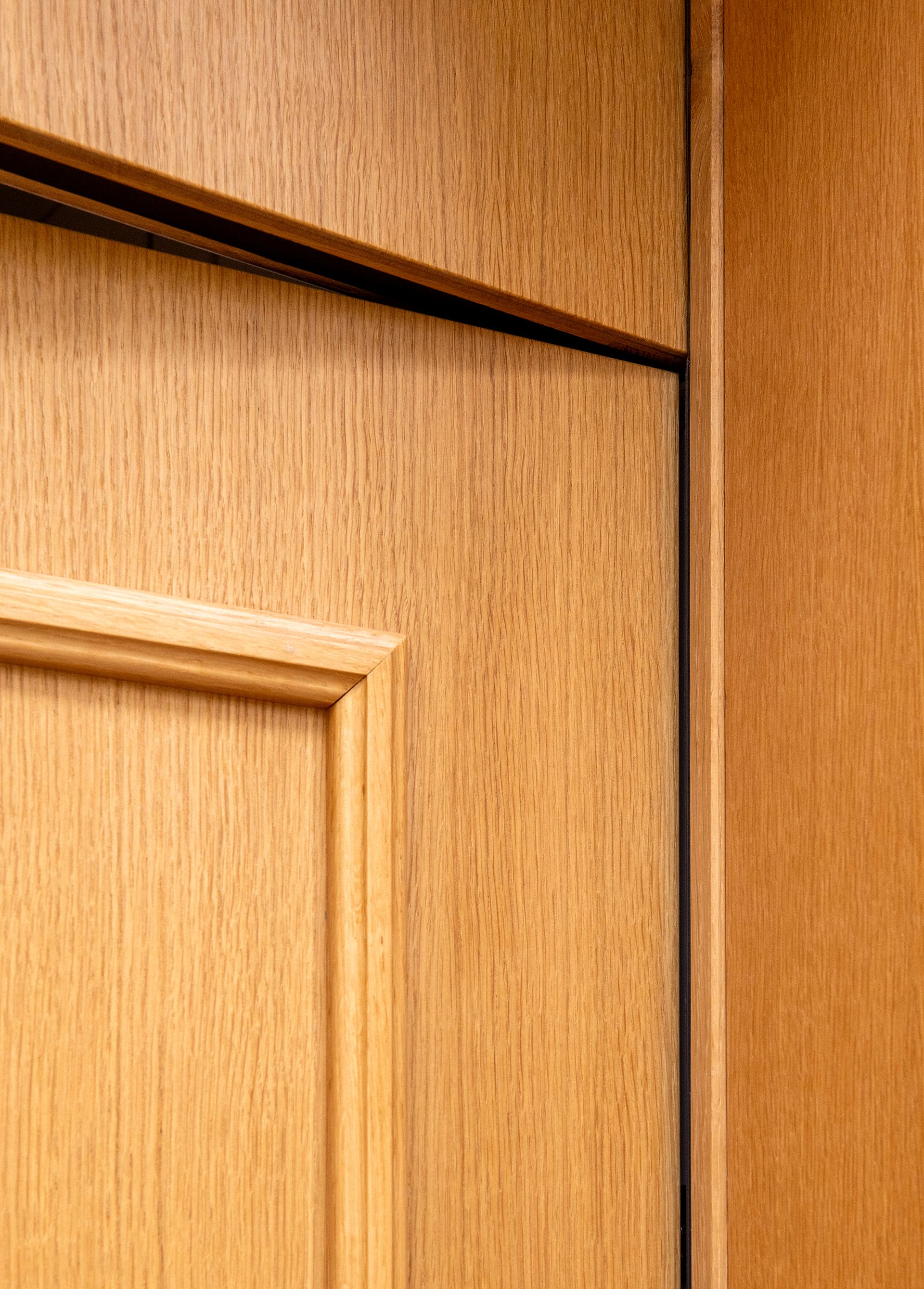 Intérieur de la bibliothèque : une personne est assise à un bureau, en train de lire. Des étagères bordent les murs.