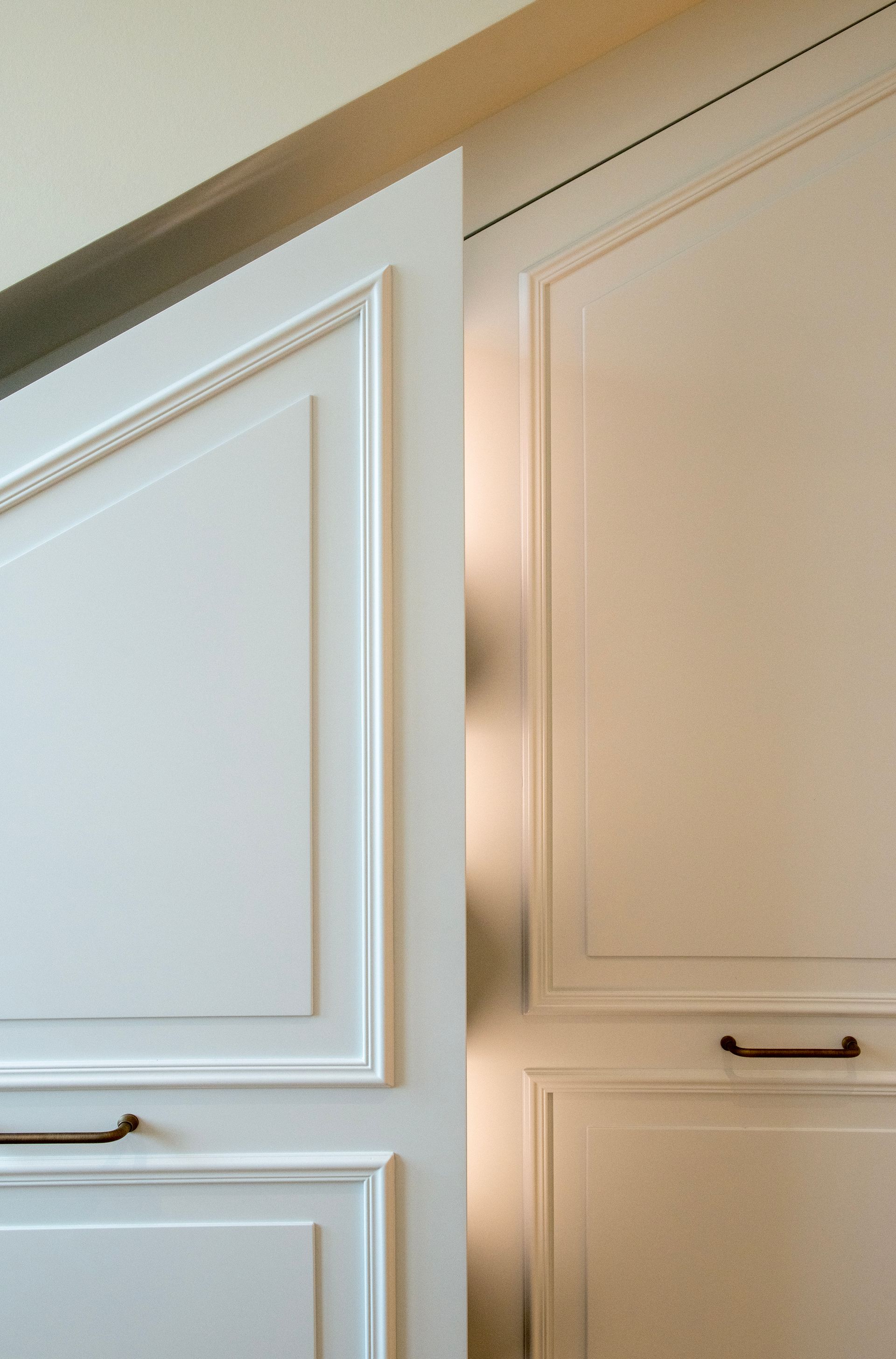 Dressing gris avec portes vitrées, parquet et bureau avec chaise près d'une fenêtre.