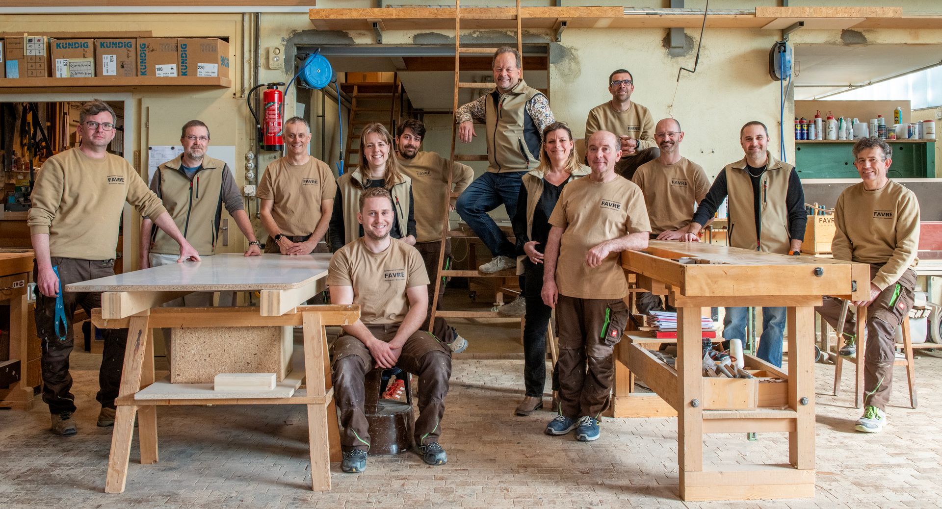 Coin salon avec mobilier bleu, mur géométrique, luminaire globe argenté et petites tables noires.