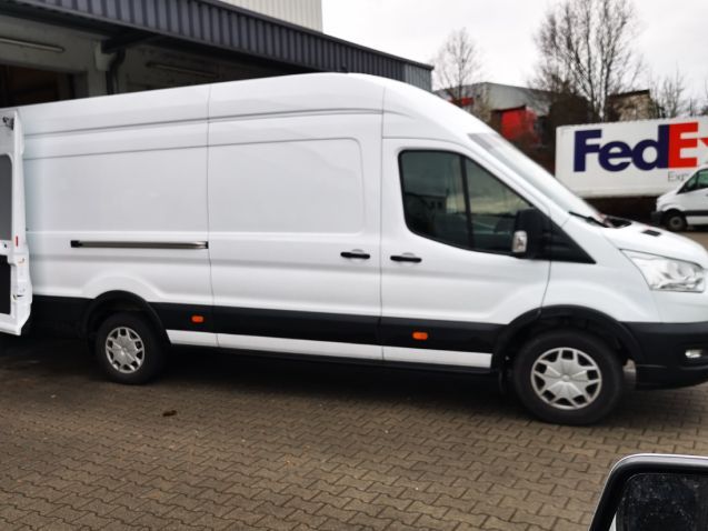 Ein weißer FedEx-Lieferwagen steht vor einem Gebäude