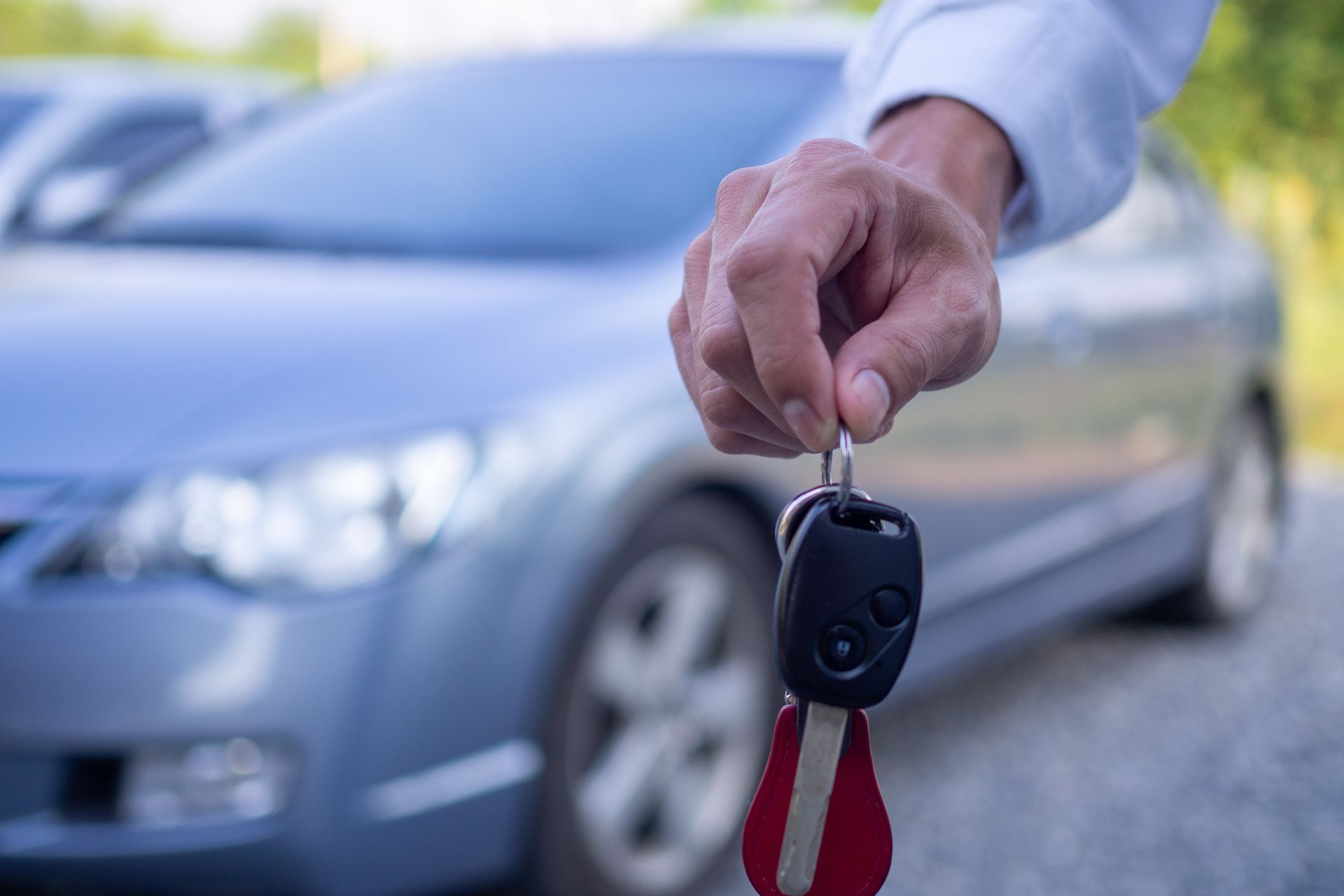 Homme tenant à la main les clés d'une voiture