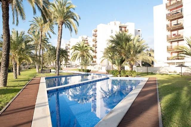 Una gran piscina rodeada de palmeras y edificios.