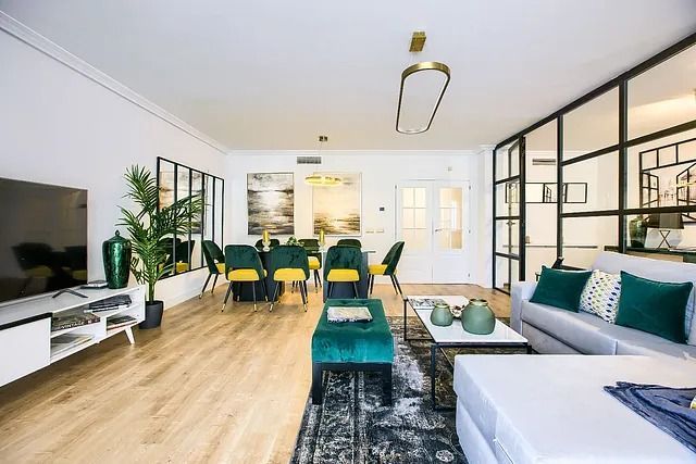 Una sala de estar con sofá, televisión, mesa de comedor y sillas.