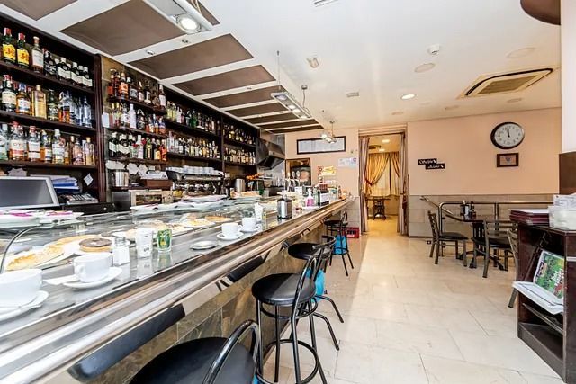 Un restaurante con una barra larga y mesas y sillas.