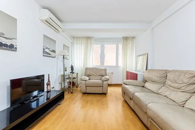 Una sala de estar con un sofá, una silla y un televisor.