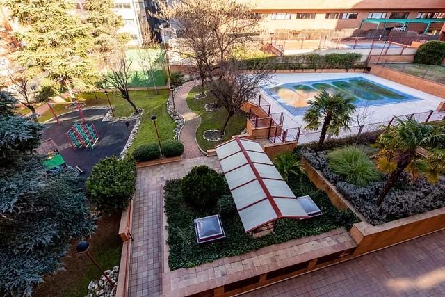 Una vista aérea de un parque con piscina y zona de juegos infantiles.