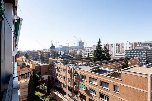 Una vista de una ciudad desde un balcón de un edificio de ladrillo.
