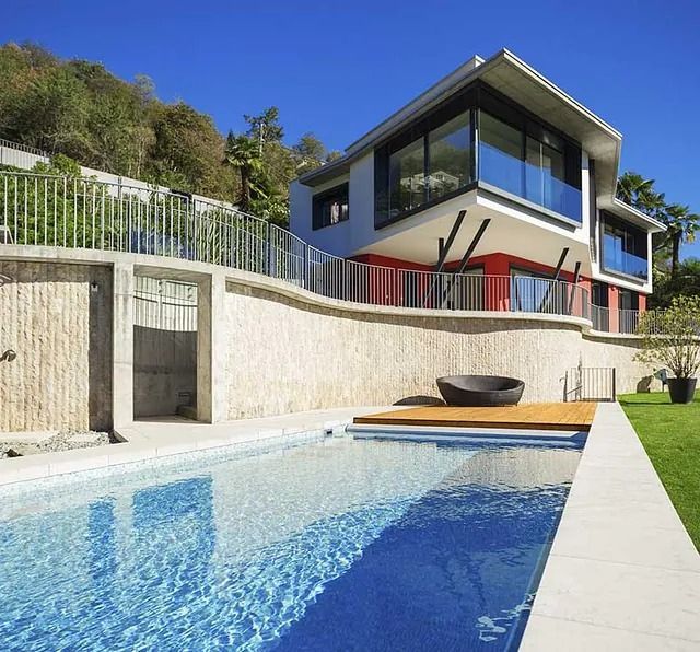 Una casa grande con piscina delante de ella.