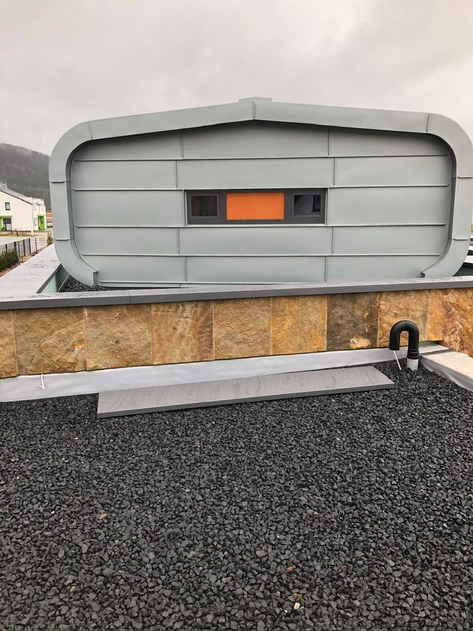 Flachdach mit schwarzen Steinen