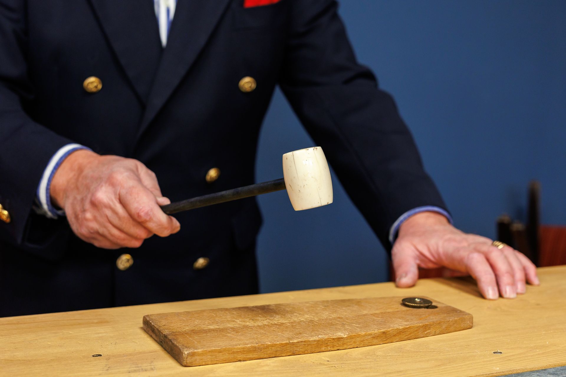 Main tenant un marteau dans une salle des ventes