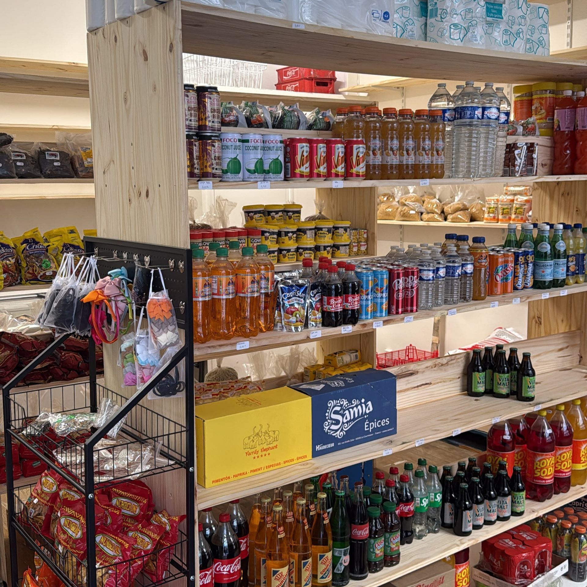 Rayon d’épicerie avec un assortiment de boissons en bouteille, de boissons en canette et de snacks emballés.