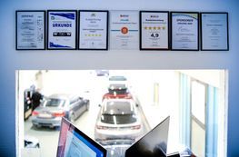 Handschlag zweier Personen neben einem Auto