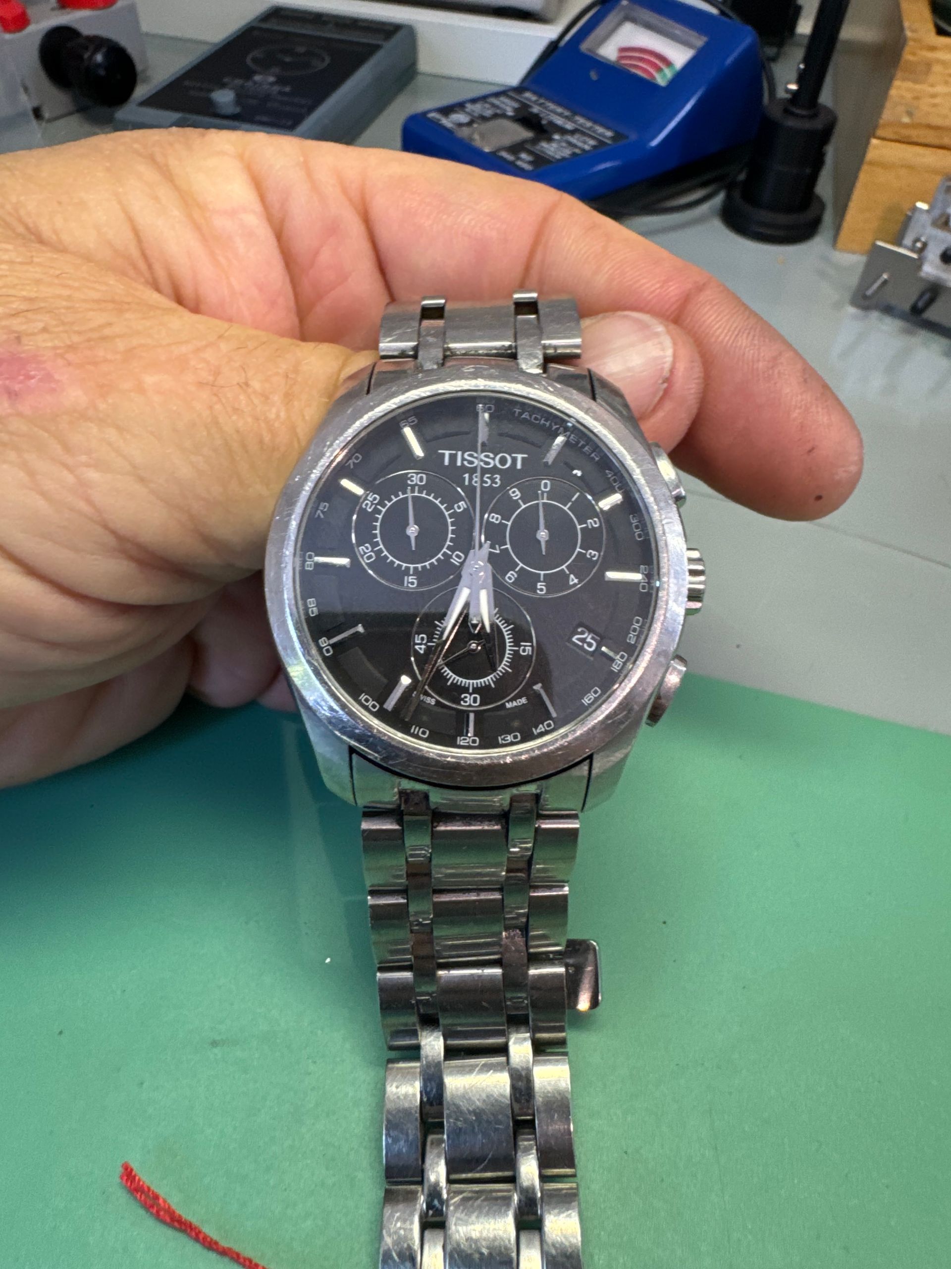 Une montre grise TISSOT.