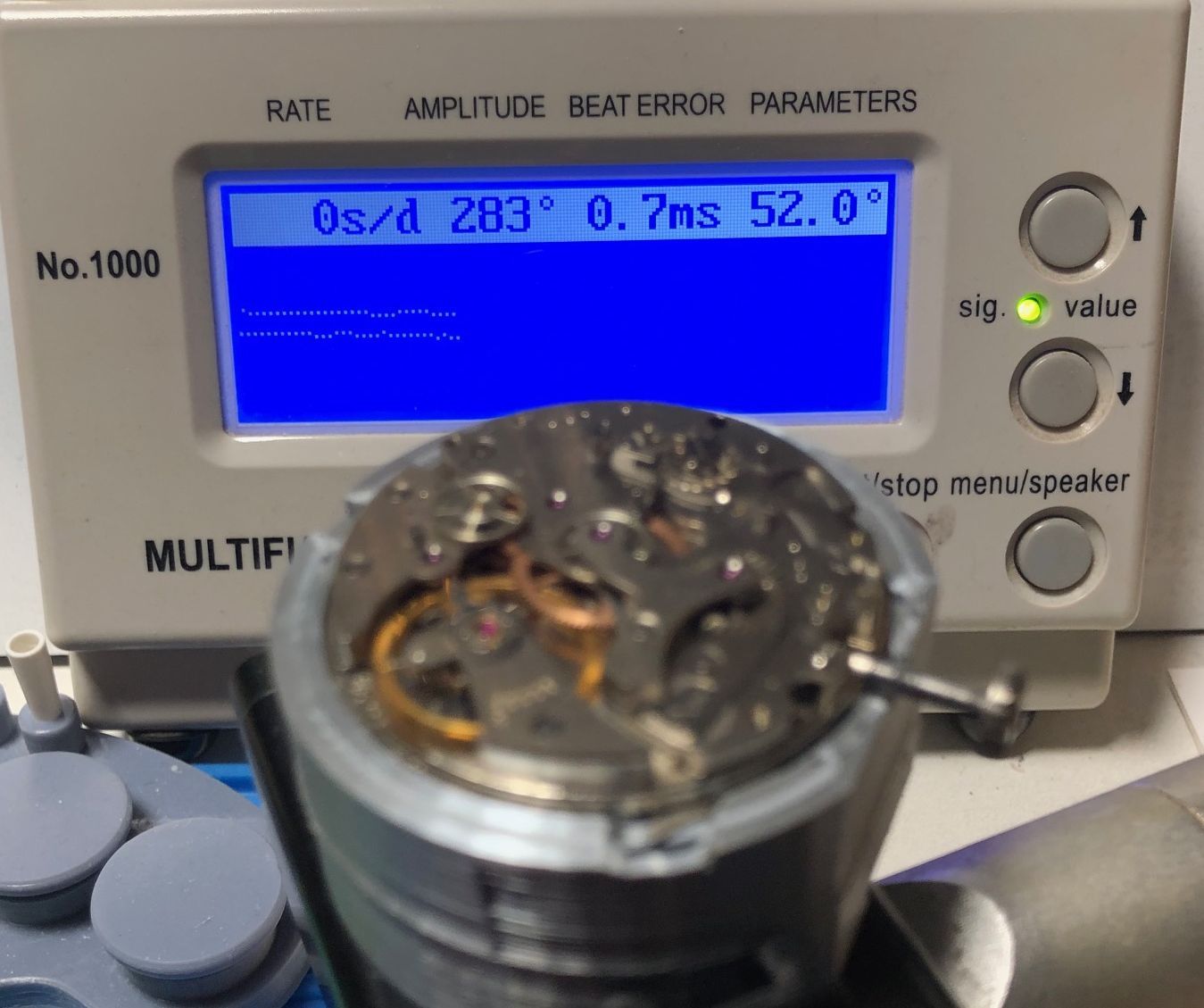 Un mécanisme de montre devant un appareil.