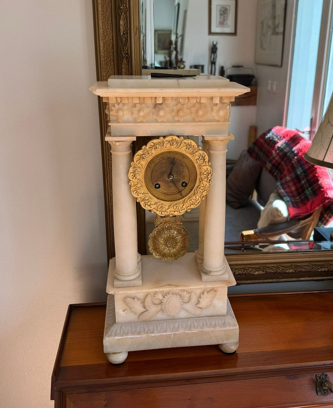 Une horloge blanche et dorée.