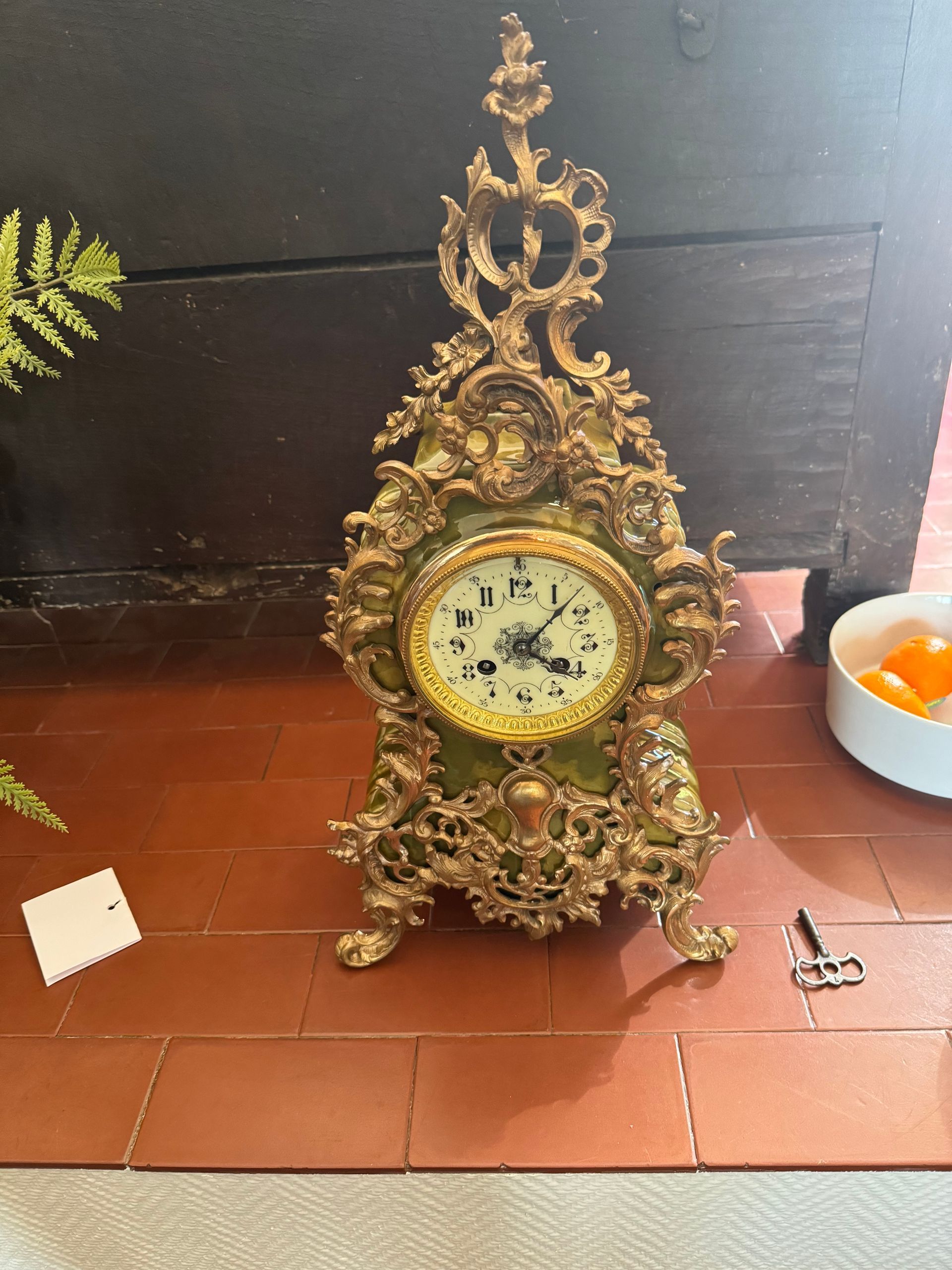 Une pendule dorée posée sur le sol.