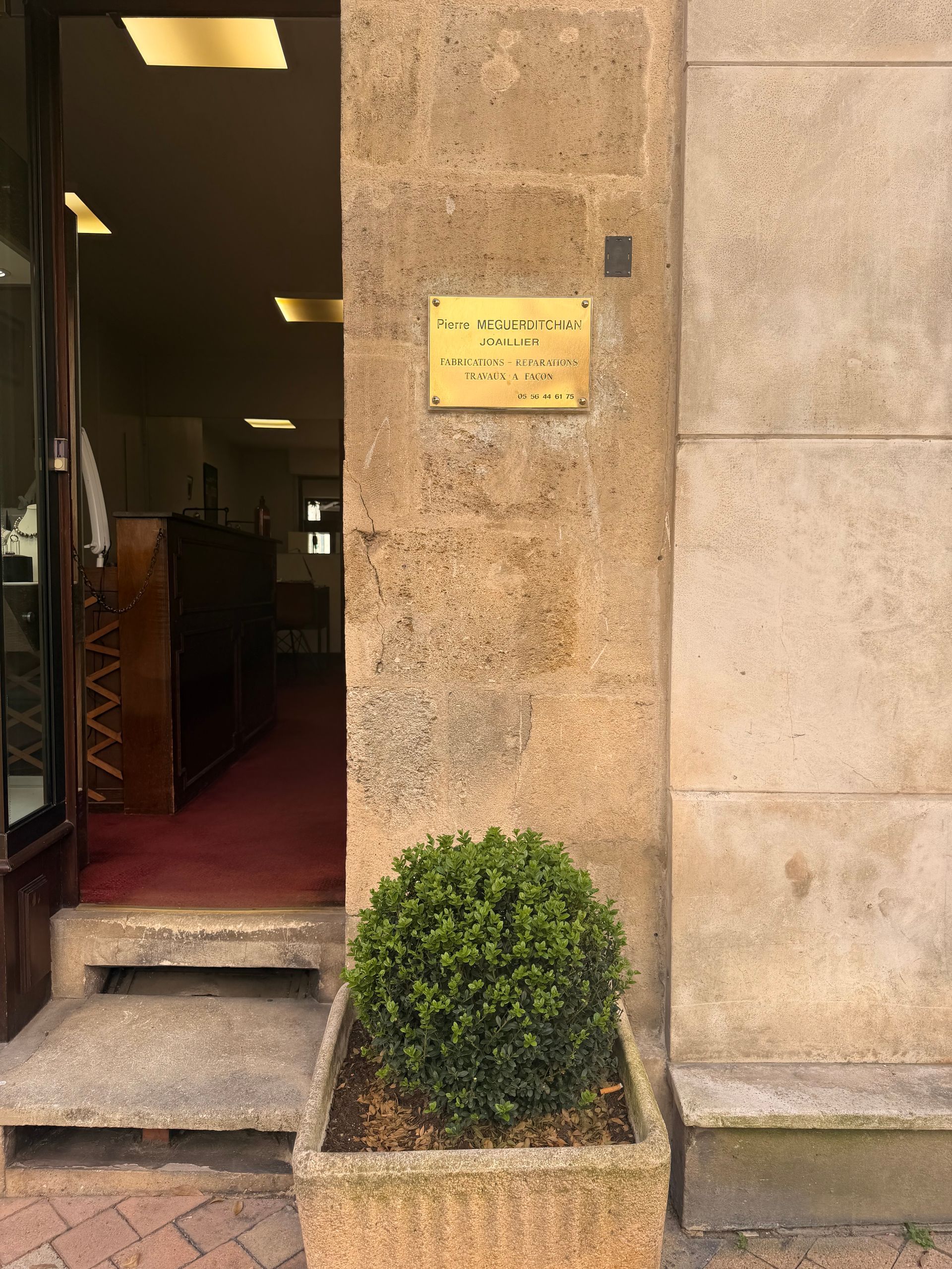 Entrée de la boutique de PIERRE MEGUERDITCHIAN, joaillier, avec son nom gravé sur une plaque en laiton.