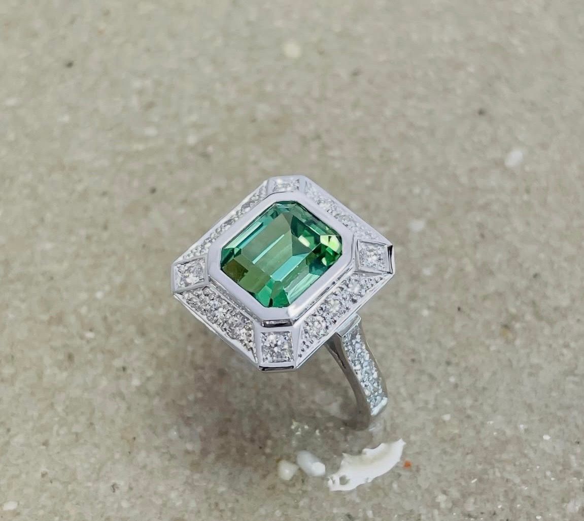 Bague rectangulaire en or blanc palladié, avec une tourmaline verte.