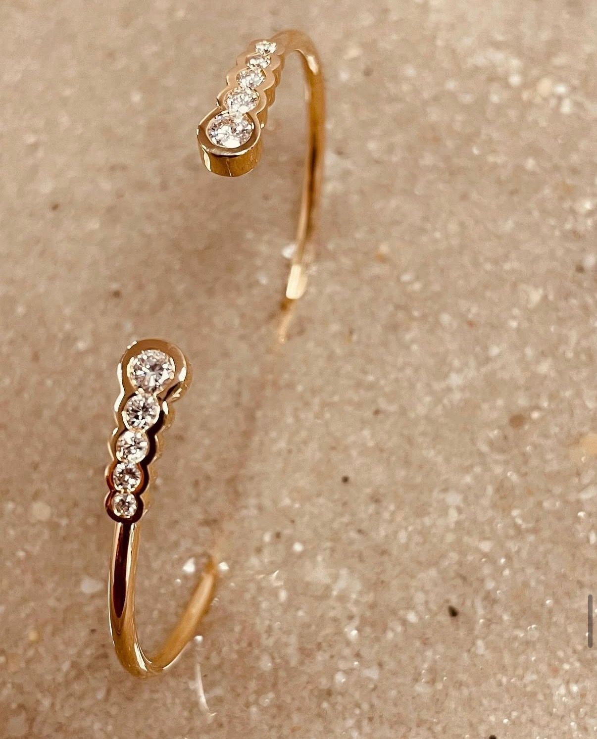 Bracelet manchette festonné en or et serti de diamants.