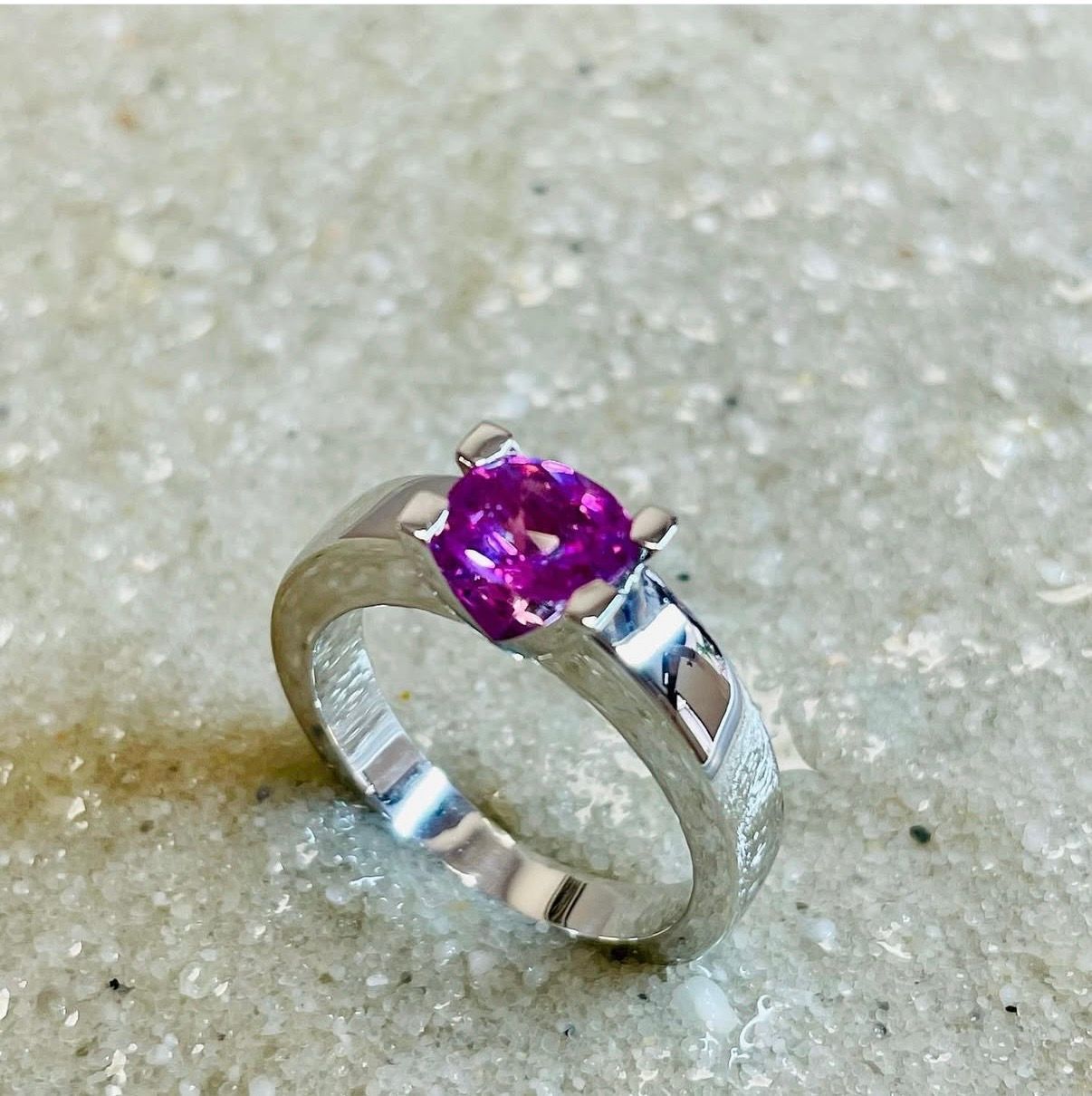 Bague en or blanc palladié avec un saphir rose carré.