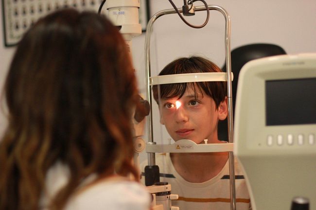 Un niño pequeño está siendo examinado por un oftalmólogo.