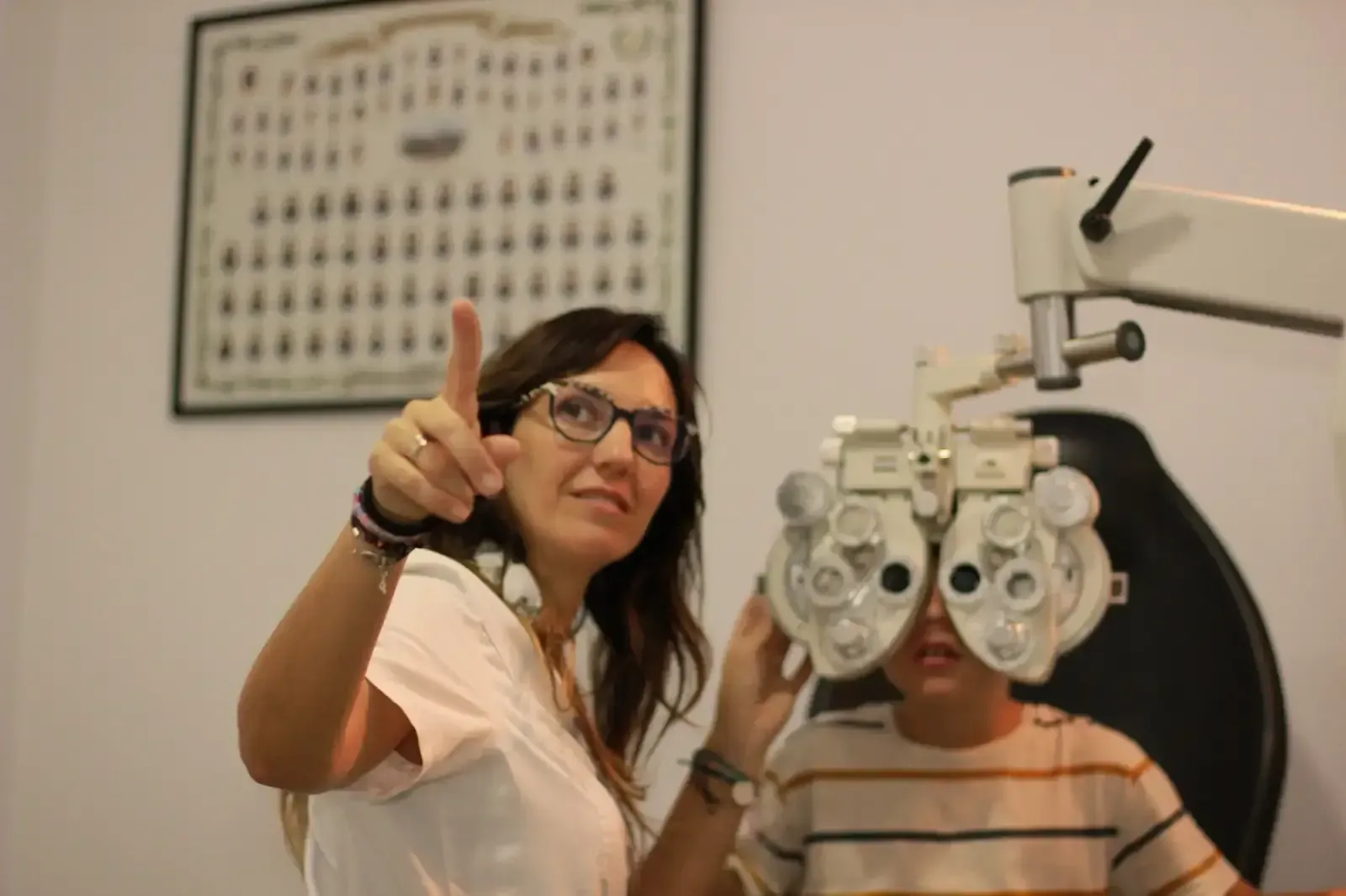 Una mujer levanta el pulgar mientras mira a los ojos de un niño.