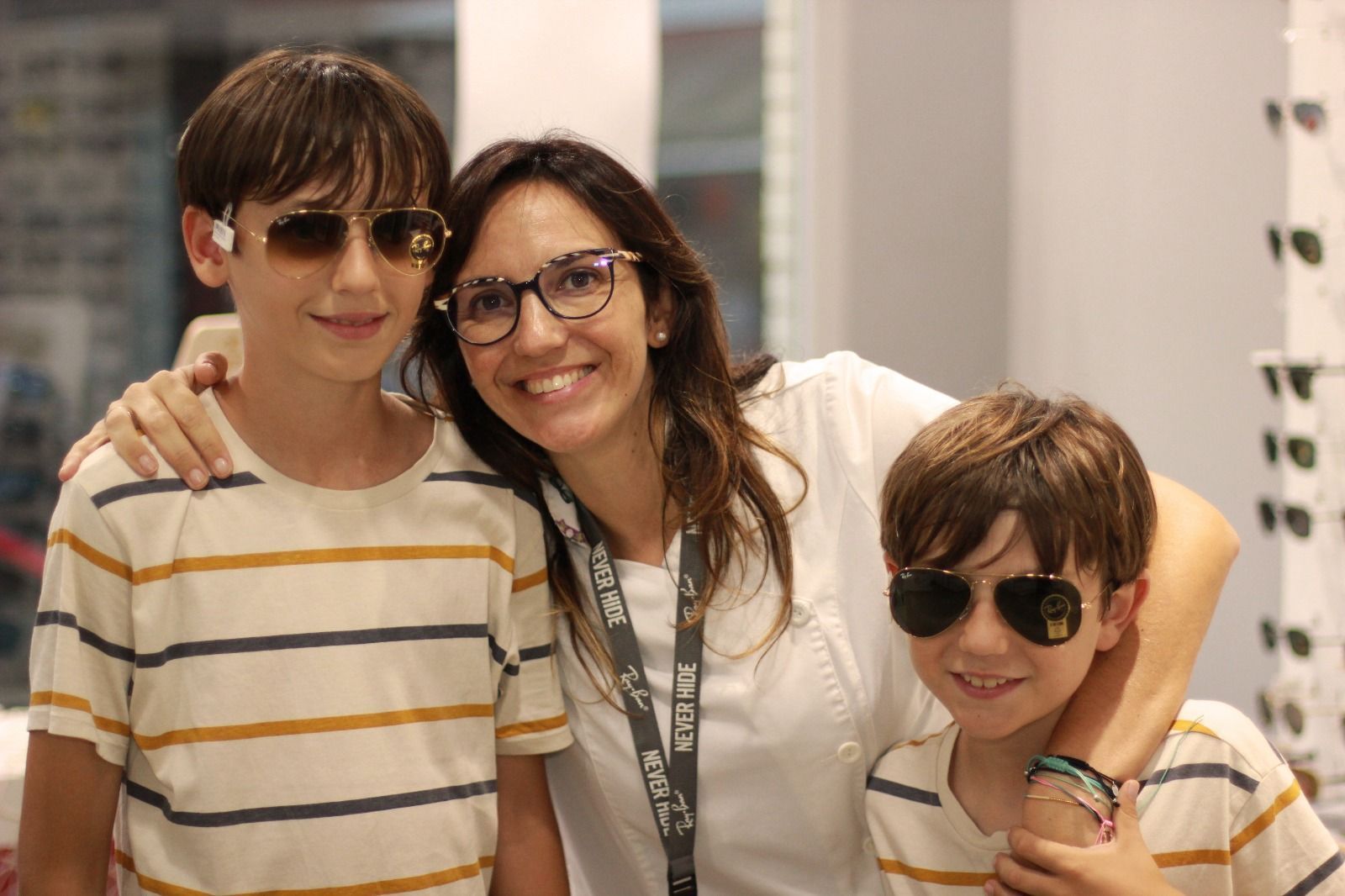 Una mujer y dos niños con gafas de sol posan para una fotografía.