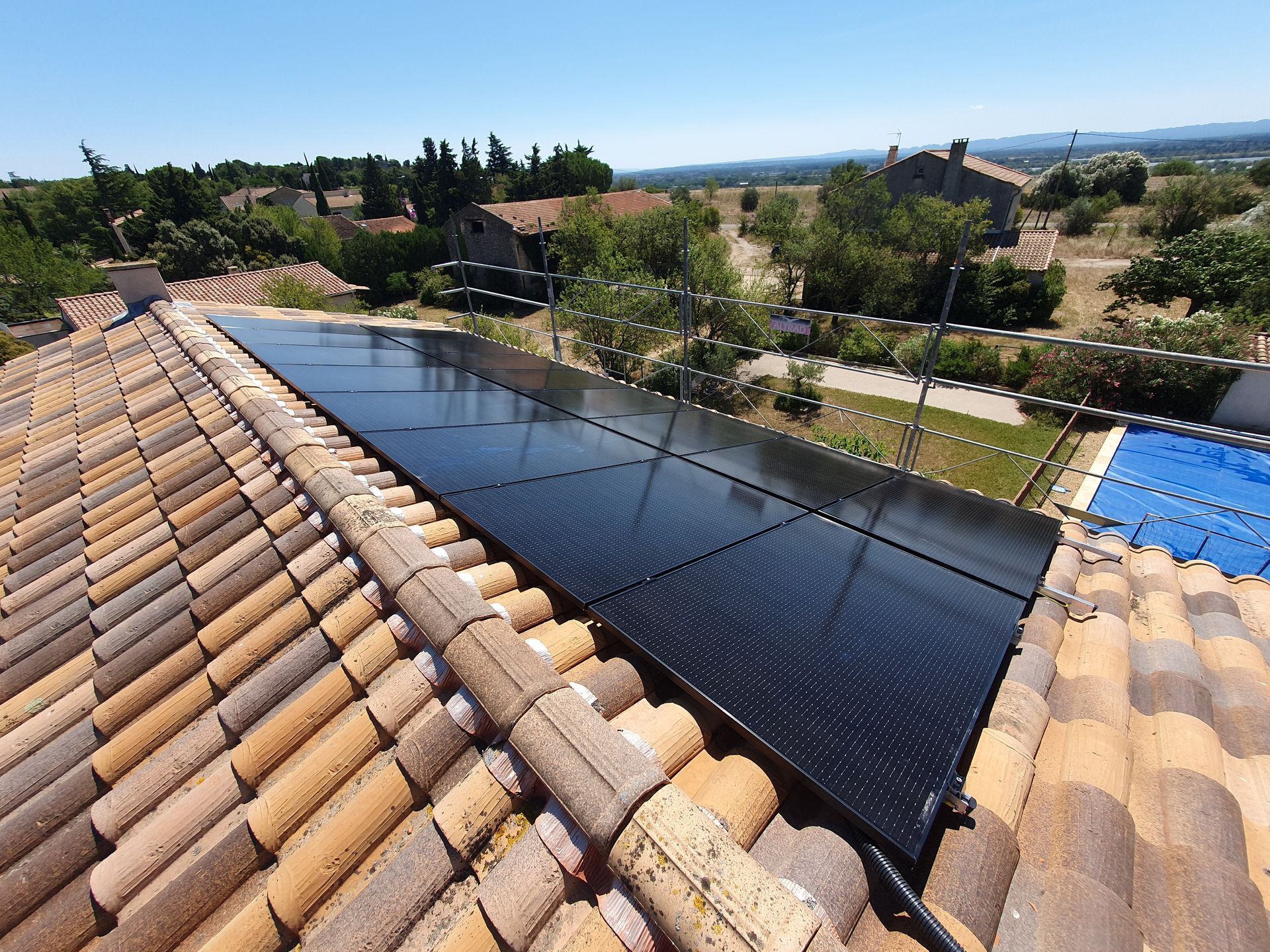 Panneaux solaires noirs installés sur un toit en tuiles