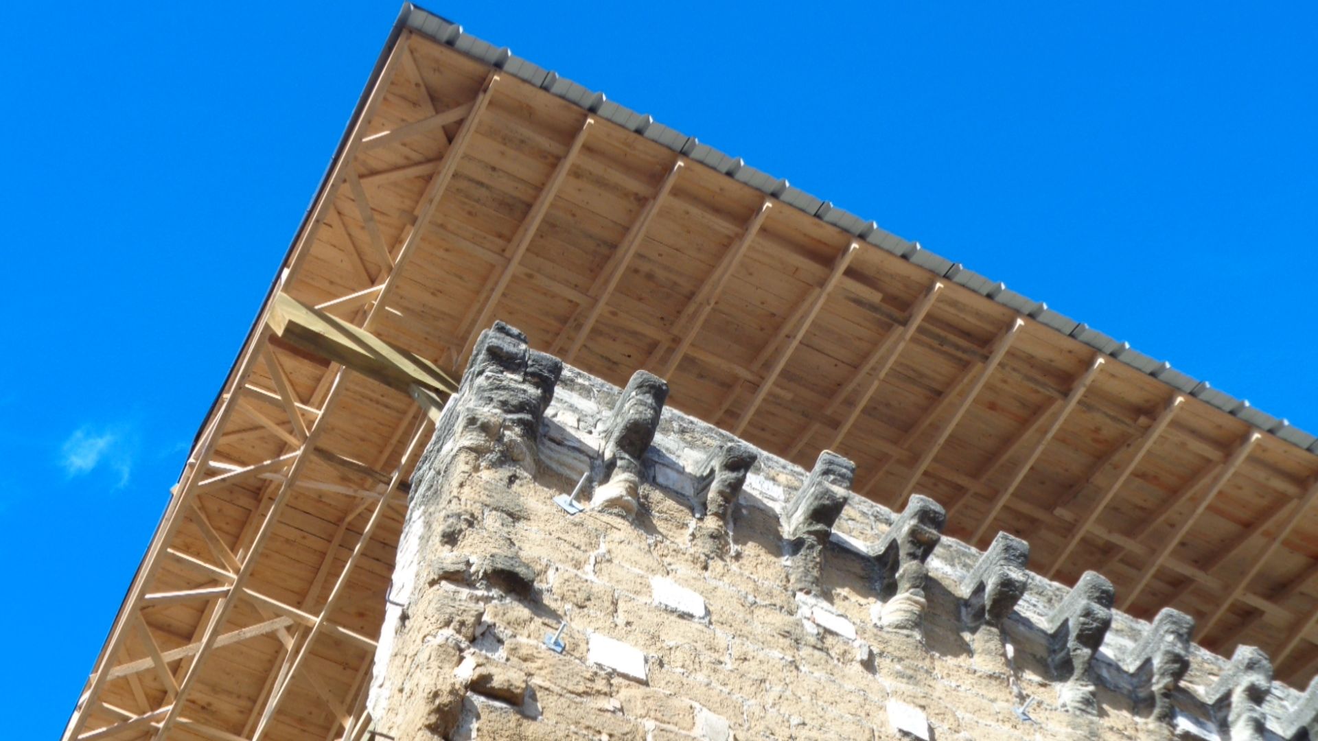 Charpente qui dépasse du toit d'un ancien bâtiment
