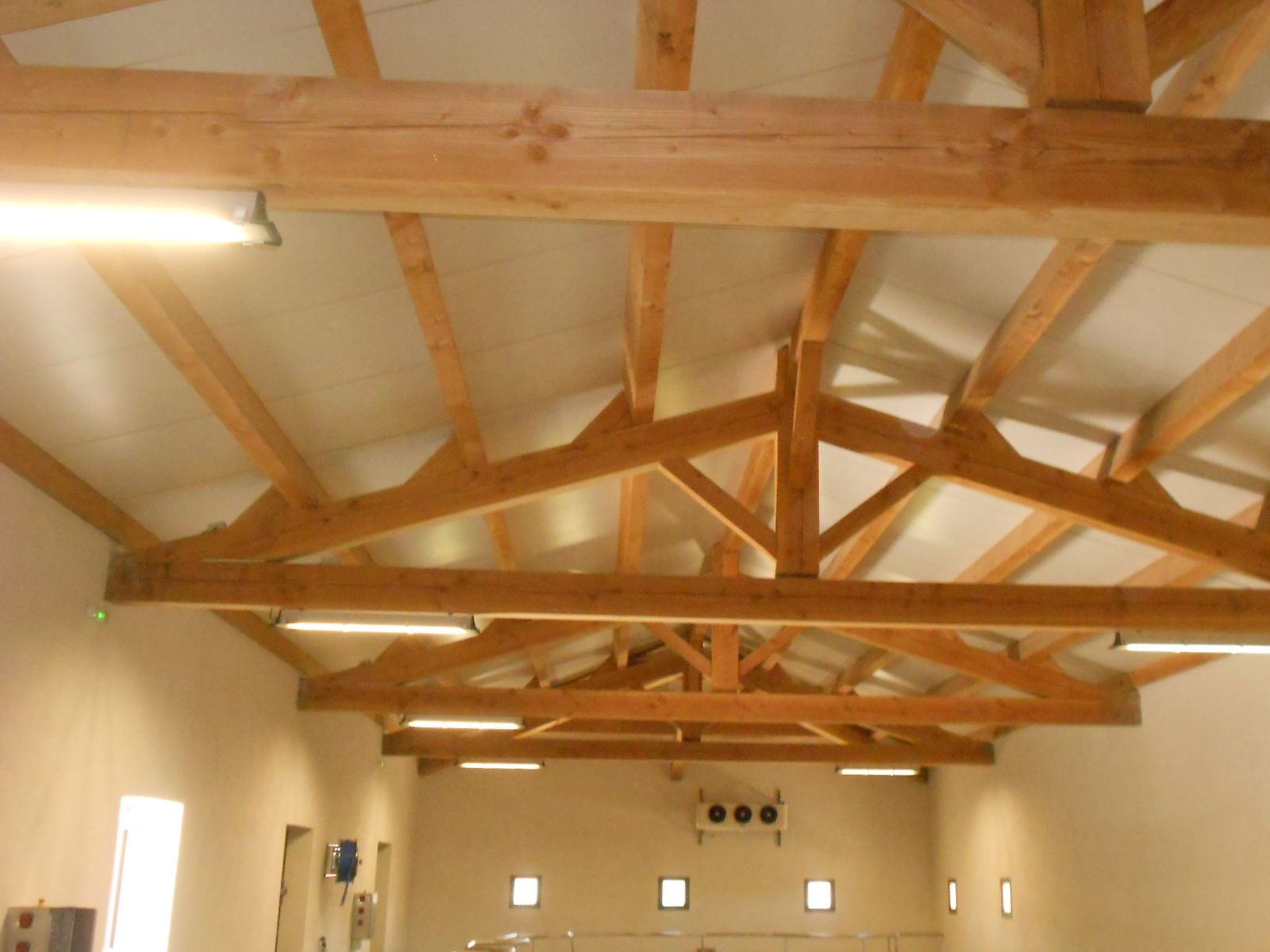 Intérieur d'un bâtiment avec charpente apparente - néons sur les poutres