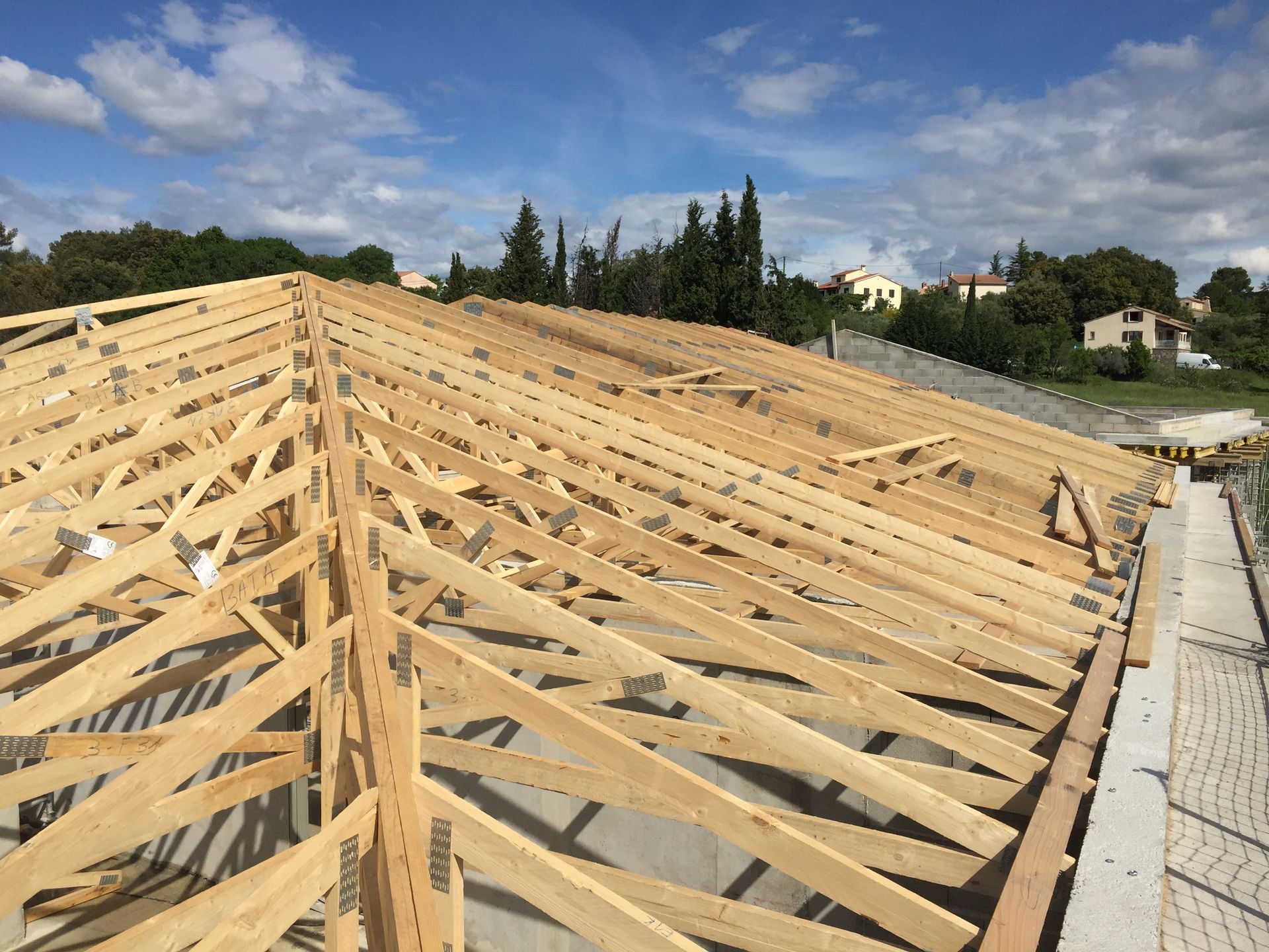 Charpente de type fermette en bois, poutres et chevrons installés.