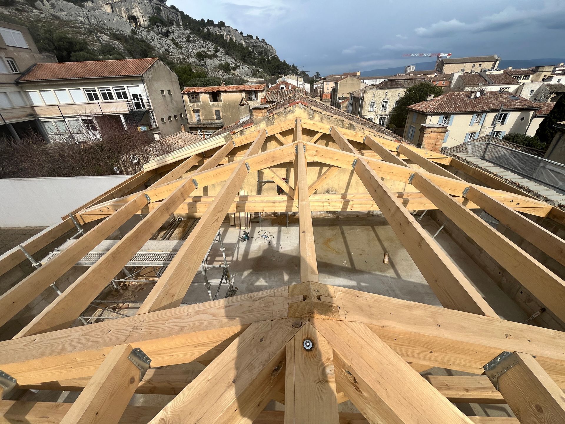 Pose d'une charpente en bois sur un bâtiment en ville