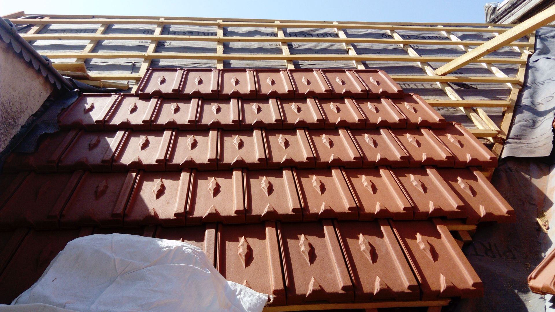 Pose de tuiles plates, foncées, avec des motifs