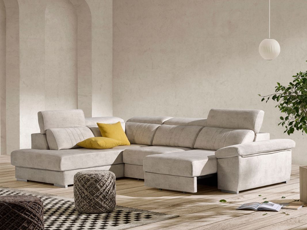 Una sala de estar con un sofá seccional blanco y una planta en maceta.