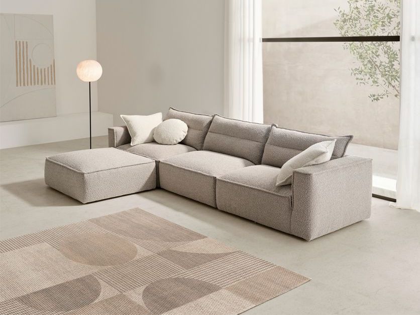 Una sala de estar con un sofá grande y una alfombra.