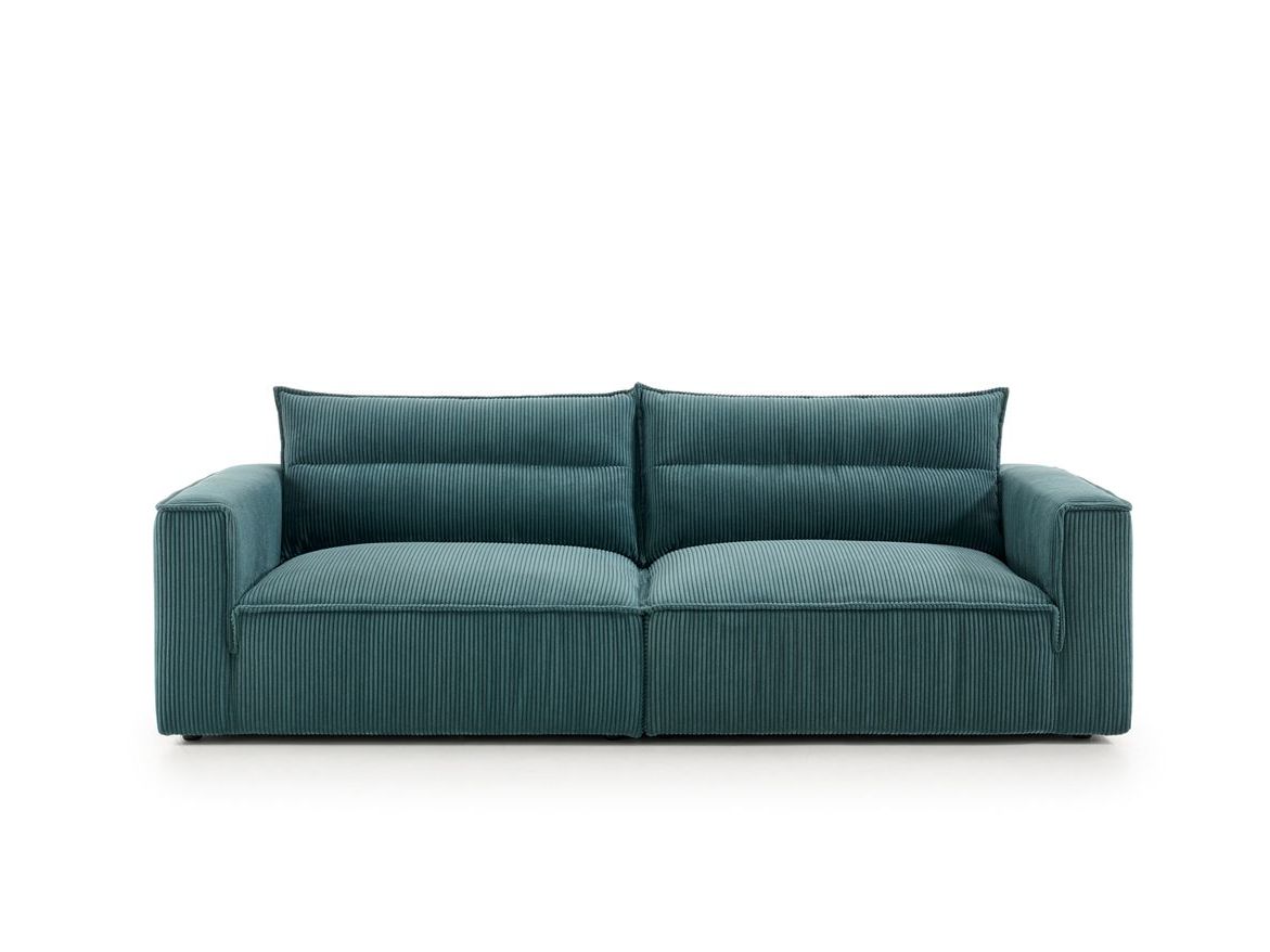 Un sofá azul con dos almohadas sobre un fondo blanco.