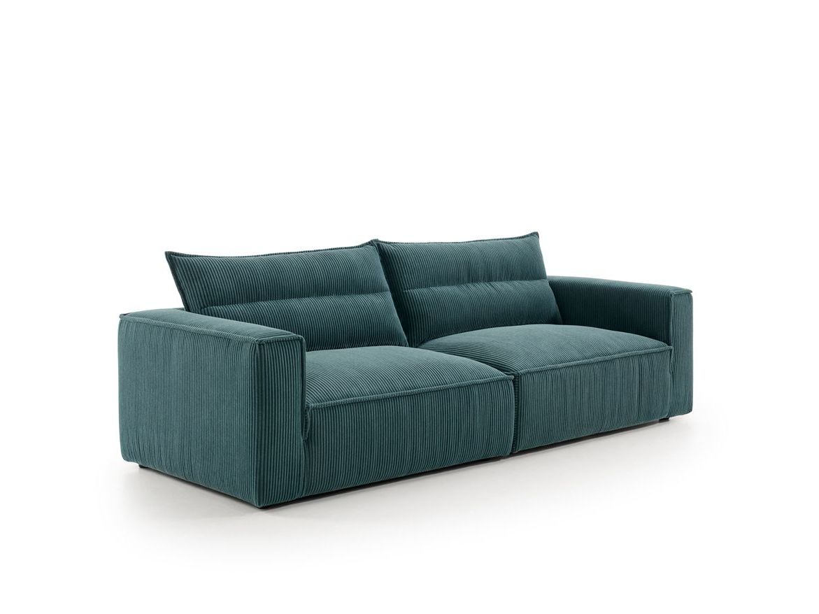 Un sofá azul con almohadas sobre un fondo blanco.