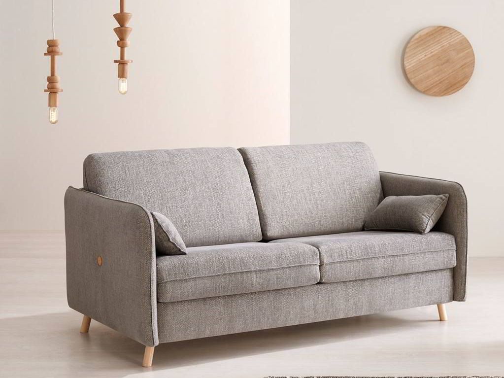 Un sofá gris está sentado en una sala de estar al lado de una mesa de café.