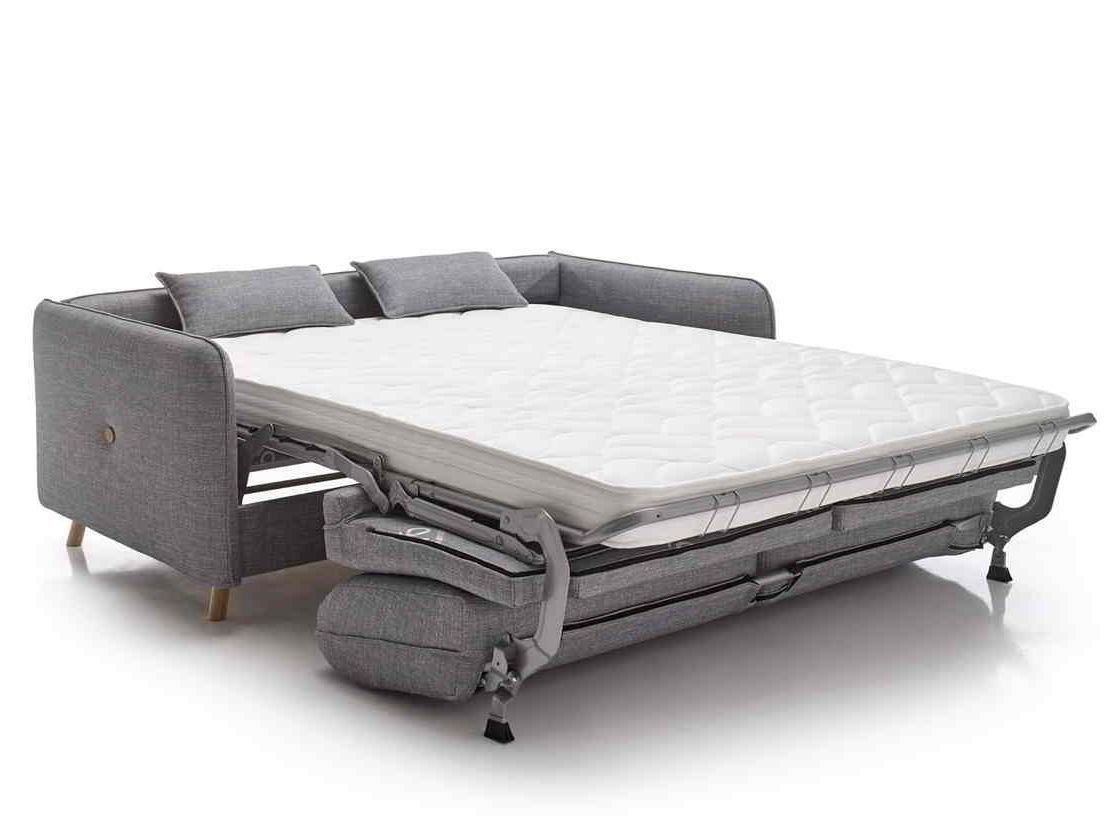 Un sofá gris que se ha convertido en cama.