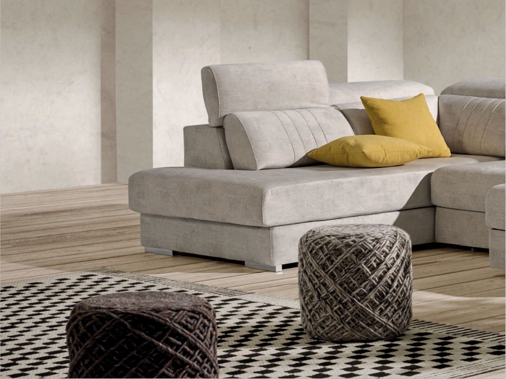 Una sala de estar con un sofá seccional y dos otomanas.